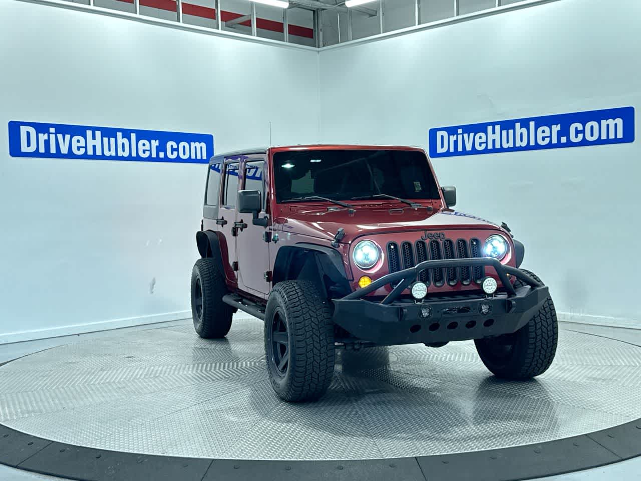 2013 Jeep Wrangler Unlimited Sport in Deep Cherry Red Crystal Pearl — front three-quarter view